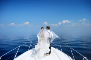 Happy bride and groom hugging on a yacht