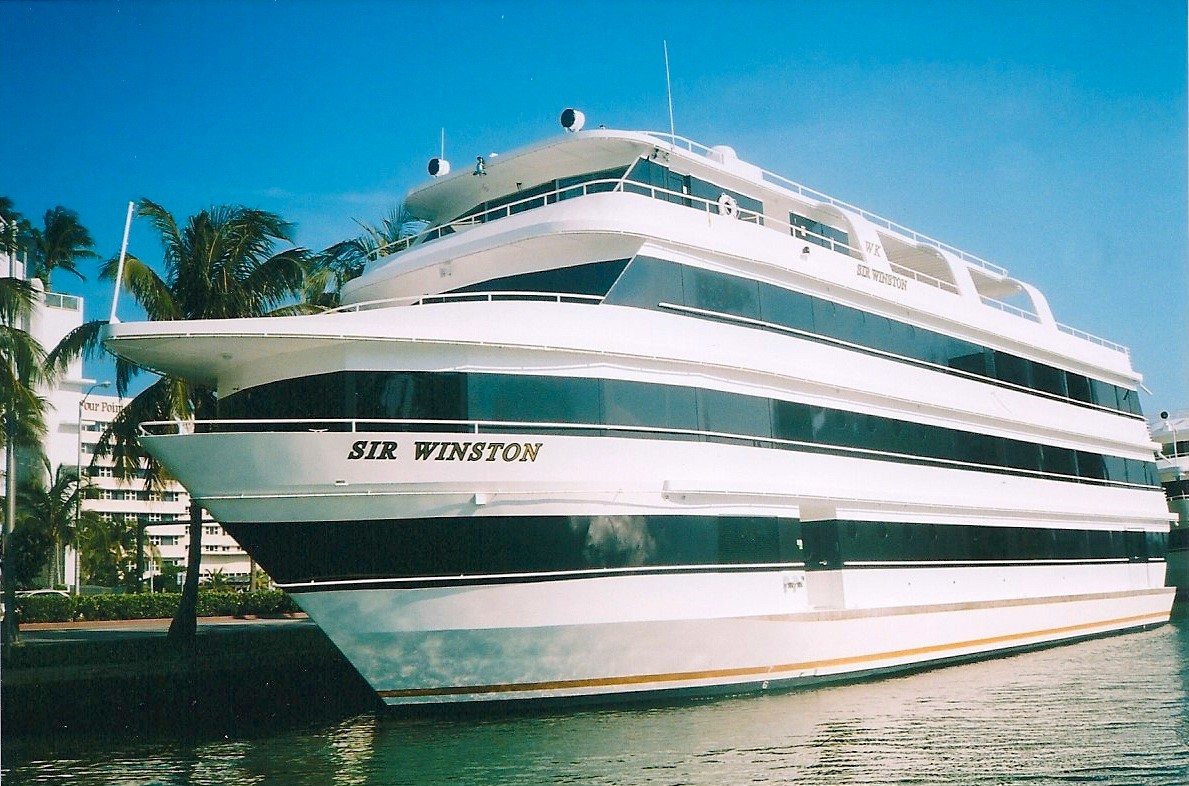 A Large White Boat Is Securely Docked at the Marina, With Calm Water Surrounding It.