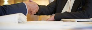 Trade association colleagues shaking hands while at an event on a luxury yacht