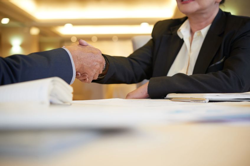 Trade association colleagues shaking hands while at an event on a luxury yacht